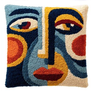 May include: A square throw pillow featuring a textured, tufted abstract face design. The composition uses a bold color palette of navy blue, light blue, cream, mustard yellow, and burnt orange, creating a stylized facial portrait with prominent eyes.