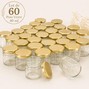 Peut inclure: Un lot de 60 petits pots en verre transparent, chacun d'une capacité de 40 ml, surmontés d'un couvercle métallique doré à visser. Les pots sont disposés en groupe, certains couvercles sont posés à côté, avec le texte Lot de 60 Pots Verre 40 ml.