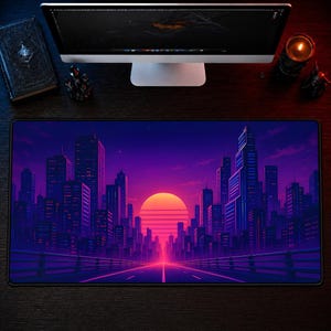 May include: A rectangular desk mat featuring a vibrant digital illustration of a city skyline at sunset. The scene displays purple and blue skyscrapers silhouetted against a large, glowing orange sun, with a road leading toward the horizon.