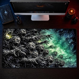 May include: A rectangular mouse mat with a detailed illustration of zombies with open mouths and reaching hands. The artwork is predominantly black and grey, with green and yellow accents. The mouse mat is on a dark wooden surface.