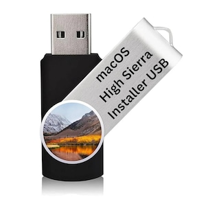 Może przedstawiać: Czarny pendrive USB ze srebrną metalową obrotową osłoną. Na osłonie znajduje się napis "macOS High Sierra Installer USB". Okrągły obraz krajobrazu górskiego znajduje się na czarnym korpusie.