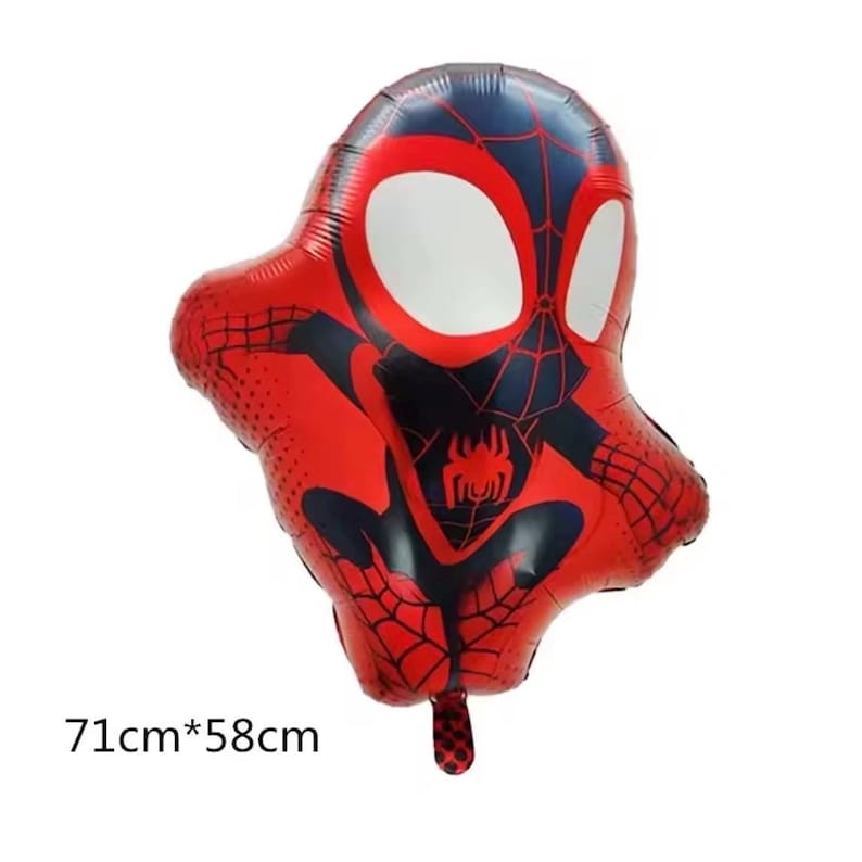 May include: A red and blue foil balloon shaped like a stylized superhero character with large white eyes and a spider emblem on the chest. The balloon features a black web pattern and measures 71cm by 58cm as indicated by the printed text.