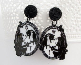 Woman with cat and pentagram earrings, big black and white witch dangle statment earstuds