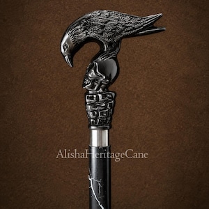 May include: A walking cane featuring a black handle shaped like a raven perched atop a human skull, which rests on a textured base. The shaft is black with white marble-like veining. The text AlishaHeritageCane is printed on the shaft.