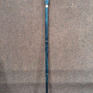 May include: A walking stick featuring a black handle shaped like a bird perched on a skull. The shaft is dark green with thin white marble-like veining and two gold-colored metal bands separating the segments. The base has a small metal tip.