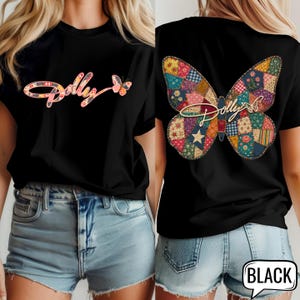 May include: A black t-shirt featuring a front graphic with the word Dolly in a patchwork butterfly pattern and a back graphic of a large patchwork butterfly with the word Dolly written across the center in a light-colored script font.