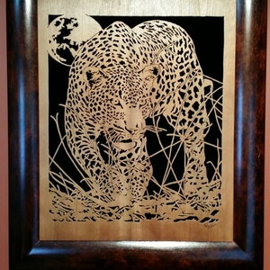 Hand cut wooden portrait of a leopard stalking its prey at night