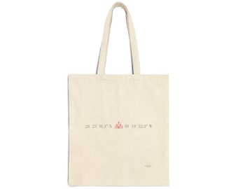May include: A natural-colored canvas tote bag featuring a small pink castle icon centered between the coordinates 28 25' 11.3" N 81 34' 52.3" W printed in black ink. The bag has two long shoulder straps and the letters OMP in the bottom right corner.