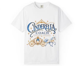 May include: A white short-sleeve t-shirt featuring a graphic print with the text "Cinderella Coach Limousine Company" in blue and gold. The design includes a golden crown, a horse-drawn carriage, and a white horse surrounded by small gold stars.