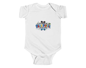 May include: A white short-sleeved baby bodysuit featuring a colorful graphic print that reads MY PARENTS ARE PARK PEOPLE I HAD NO CHOICE, accompanied by illustrations of a castle, palm tree, mouse ears, and blue sunglasses.