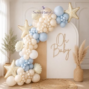Può includere: Un arco di palloncini color crema e azzurro, con palloncini in lamina a forma di stella marina dorata e palloncini a forma di conchiglia. Uno sfondo ad arco bianco mostra la scritta Oh Baby in corsivo dorato e il logo SevenPartyCo.