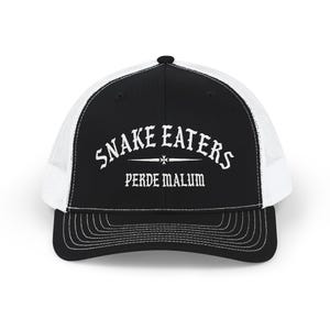May include: A black and white trucker cap with a mesh back and a solid front panel. The front features the white text SNAKE EATERS arched over a small cross symbol, with the text PERDE MALUM printed below in a matching white gothic typeface.