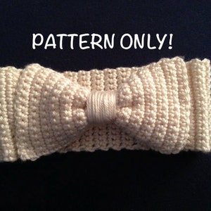 Puede incluir: Una diadema de ganchillo con un lazo de color crema. La diadema está hecha con un punto sencillo y tiene un aspecto ligeramente texturizado. El lazo está centrado en la diadema y está atado con un simple nudo.