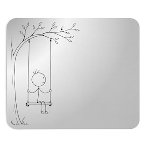 May include: A rectangular mouse pad with a metallic silver finish featuring a black line drawing of a stick figure sitting on a swing suspended from a tree branch. The design is positioned on the left side, leaving the right side blank.