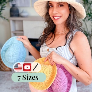 May include: A woman holding several crochet sun hats in various colors: light blue, yellow, pink, and purple. The hats are displayed with a larger cream-colored crochet sun hat. The image includes text that says "7 Sizes".