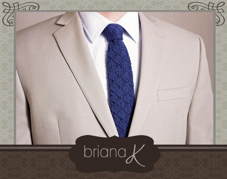 May include: A beige blazer with a blue knitted tie. The tie has a textured pattern. The text "briana K" is visible in the bottom center of the image.