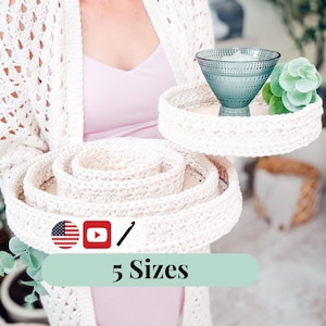 May include: A white ceramic mug with a black handle and the text "But First, Coffee" in a bold, black font. The mug is set against a plain white background, highlighting its simple design.