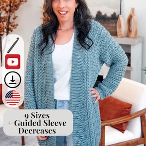 May include: A woman wearing a long, open-front, teal-colored crochet cardigan. The cardigan has a ribbed texture and is paired with a white top and blue jeans. Text on the image reads "9 Sizes + Guided Sleeve Decreases".