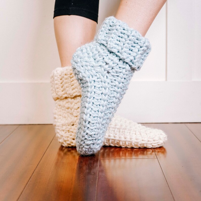 May include: A pair of knitted slipper socks, one in light blue and one in cream.