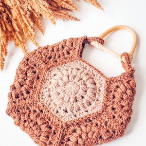A handmade gift featuring a crocheted bag with a wooden handle.