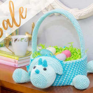 A dinosaur crochet easter basket with a handle in bright colors.