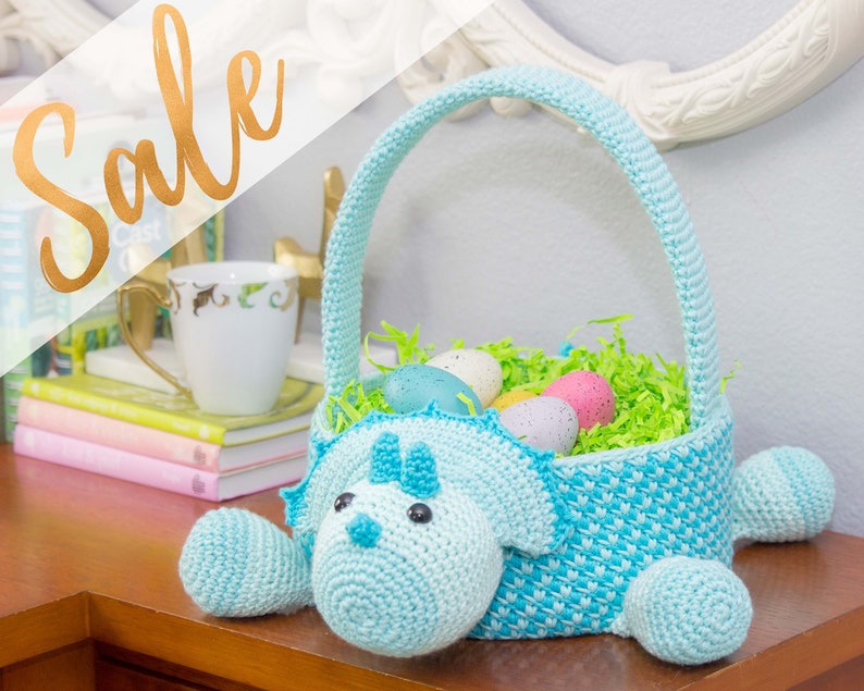 A dinosaur crochet easter basket with a handle in bright colors.