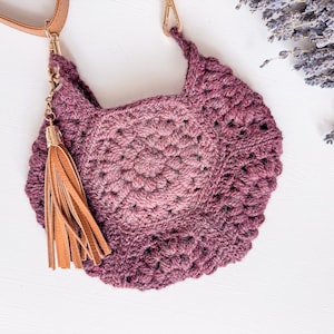 A handmade gift featuring a crocheted bag with a wooden handle.