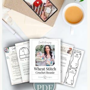 Flat lay of a crochet beanie pattern set, perfect for crafting a handmade gift, featuring printed instructions, templates, a "PDF" label, a cup of tea, and a smartphone showing a crochet video tutorial.
