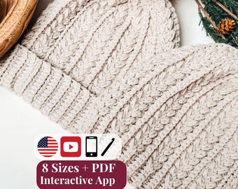 May include: Two cream-colored crocheted beanies with ribbed textures and brown faux fur pom-poms. A graphic overlay displays the text 8 Sizes + PDF Interactive App, accompanied by icons of a US flag, a play button, a smartphone, and a crochet hook.