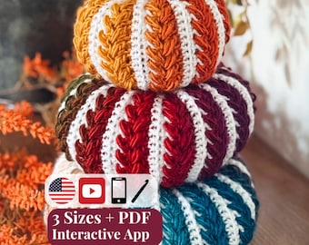Puede incluir: Una pila de tres calabazas tejidas a ganchillo en varios colores, incluyendo naranja, rojo, burdeos y azul cerceta, separadas por crestas verticales blancas. Una rama de canela sirve de tallo. Texto: 3 Sizes + PDF Interactive App.