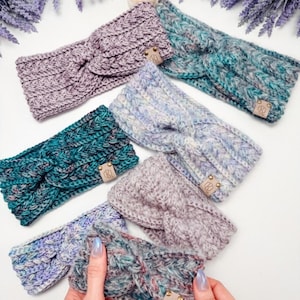 Puede incluir: Una colección de siete diademas de punto grueso con un diseño frontal retorcido. Cada diadema está confeccionada con hilo jaspeado en tonos lavanda, azul cerceta, azul y gris, e incluye una pequeña etiqueta de cuero rectangular con un logo.