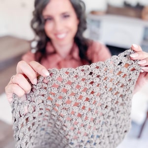 May include: A light brown crochet fabric piece featuring a repeating openwork pattern of small clusters. The textile has a textured, knotted appearance with a consistent grid-like structure throughout, showcasing the intricate hand-stitched details.