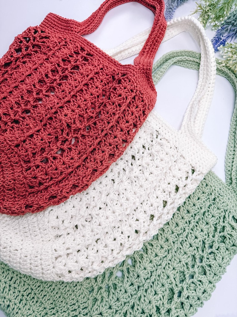 Puede incluir: Tres bolsas de mano de crochet en rojo, blanco y verde. Las bolsas tienen un patr&oacute;n de red y asas largas. Las bolsas est&aacute;n hechas de un hilo suave y texturizado, perfectas para llevar comestibles u otros art&iacute;culos.