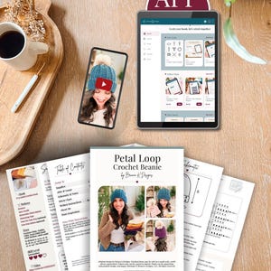 Crochet beanie pattern PDF pages, a phone showing the video tutorial, and a tablet showing the app on a wooden table