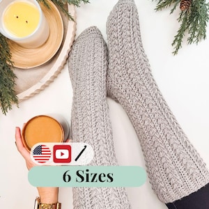 May include: A pair of light gray, textured crochet leg warmers. The image shows the leg warmers with the text "6 Sizes" on a teal background. A candle and a cup of coffee are also in the image.