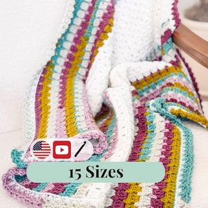 May include: A multi-coloured crochet blanket featuring stripes of teal, purple, yellow, and pink on a white base. The blanket is draped over a chair, displaying its textured design. The text "15 Sizes" is visible on the blanket.