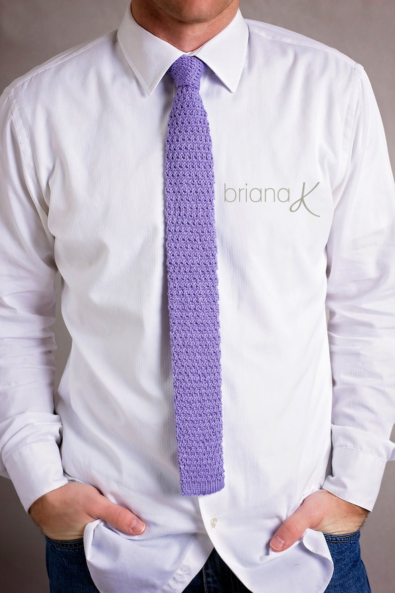 May include: A white dress shirt with a lavender knitted tie. The tie has a textured pattern.