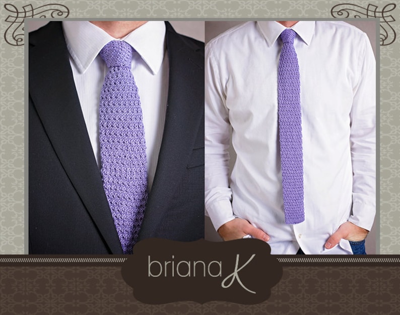May include: A purple knitted tie with a textured pattern. The tie is worn with a white dress shirt and a dark suit jacket.