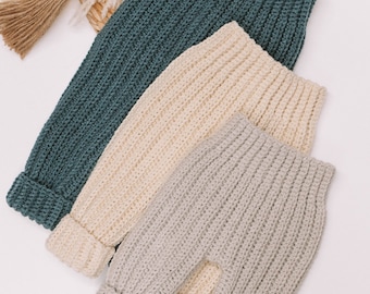 Puede incluir: Tres pantalones de punto acanalado en colores verde azulado, crema y gris claro. Cada par presenta un diseño de cintura alta con una pretina elástica gruesa y puños en los tobillos, confeccionados con un patrón de punto vertical texturizado.