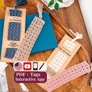 Peut inclure: Quatre marque-pages rectangulaires au crochet en bleu, beige, blanc et rose, chacun doté d'un pompon sur le dessus. Deux marque-pages sont fixés sur des cartes de présentation en carton avec le texte Handmade Bookmark et 100% Handmade One of a Kind.