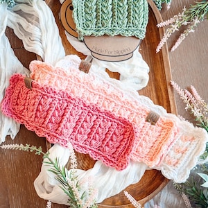 May include: A collection of handmade crochet headbands in shades of pink, white, and green, arranged on a wooden tray. The headbands feature a textured, ribbed design and are adorned with small leather tags. The text "Made For Sipping" is visible.