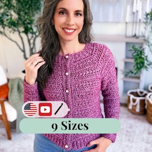 May include: A magenta crochet cardigan with pearl buttons. The image includes the text "9 Sizes" on a green banner. The cardigan is worn with blue jeans. The background includes greenery and a fireplace.