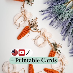 May include: A handmade Easter garland featuring crocheted orange carrots and white bunny shapes. The garland is strung with twine and accented with green and brown yarn. The image also includes a sprig of lavender and the text "+ Printable Cards".