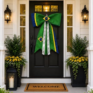 Peut inclure: Un grand nœud décoratif aux couleurs verte, jaune et bleue du drapeau brésilien, orné de petits emblèmes de drapeau et de rubans blancs imprimés avec le texte Called To Serve, fixé sur une porte d'entrée noire avec un paillasson.