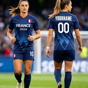 K&ouml;nnte beinhalten: Ein dunkelblaues Fu&szlig;balltrikot mit passender Hose. Auf der Brust steht FRANCE 2026 mit einer franz&ouml;sischen Flagge, w&auml;hrend auf der R&uuml;ckseite der Schriftzug YOURNAME &uuml;ber der Nummer 00 zu sehen ist. Die Hose zeigt die Nummer 10 und eine Flagge.