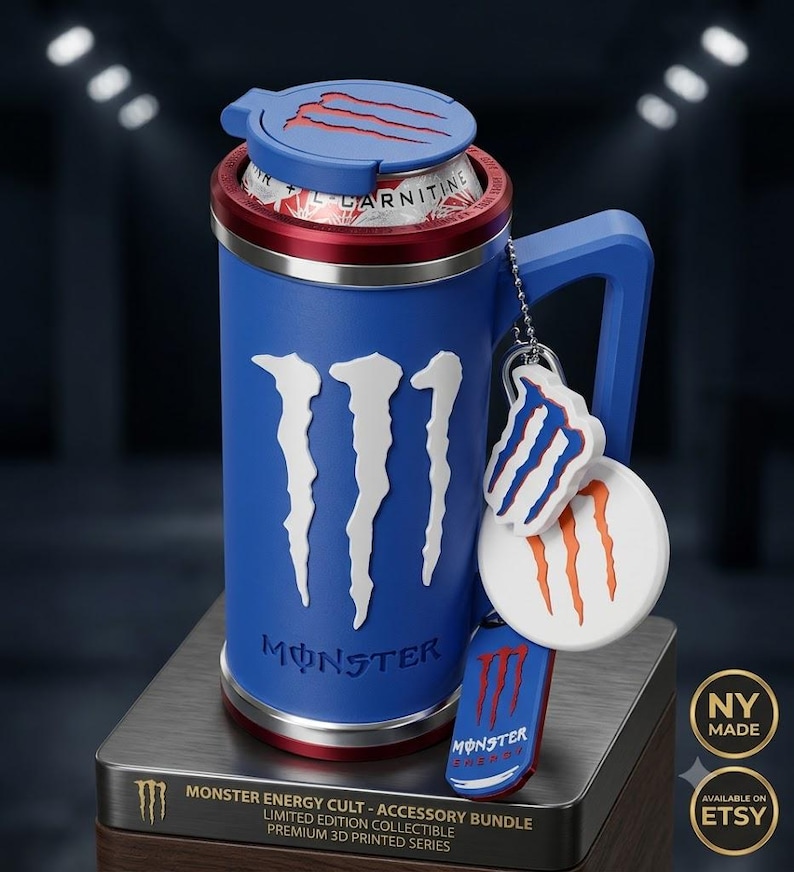 K&ouml;nnte beinhalten: Ein blauer 3D-gedruckter Dosenhalter mit Griff, der auf der Vorderseite das wei&szlig;e Monster Energy Logo zeigt. Der Halter verf&uuml;gt &uuml;ber einen blauen Deckel mit rotem Logo, einen roten Rand und eine Kugelkette mit drei Monster-Anh&auml;ngern.