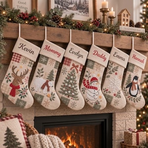 Könnte beinhalten: Sechs beige Weihnachtsstrümpfe aus Stoff hängen in einer Reihe, jeder mit einem in roter Schreibschrift eingestickten Namen am oberen Rand. Die Strümpfe zeigen festliche Patchwork-Muster mit Abbildungen von Hirsch, Eisbär, Baum, Schneemann, Schneeflocke und Pinguin.
