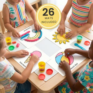May include: Four children sit around a wooden table using modelling clay on white activity mats. The mats feature outlines of a rainbow, sun, ice cream cone, and beach ball with text labels. A yellow circular graphic states 26 MATS INCLUDED.