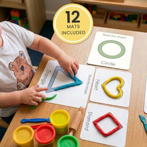 May include: A set of 12 educational shape building mats with white cards featuring black text and outlines for circle, triangle, heart, and diamond shapes. Includes colourful modelling dough, a wooden rolling pin, and plastic tools for shaping.