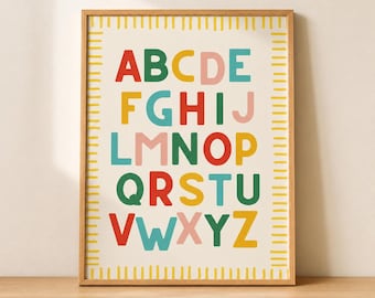 May include: A framed wall art print featuring the English alphabet in a colourful, sans-serif font. Each letter is displayed in a repeating pattern of red, green, yellow, pink, and blue. The print is enclosed in a light-toned wooden frame.